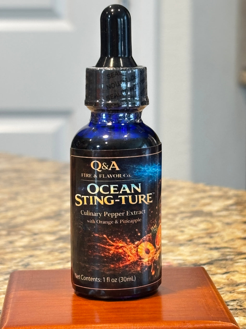 Ocean Sting-Ture Culinary Pepper Extract promotional graphic featuring a 1 fl oz dropper bottle with orange and pineapple flavor, highlighting chef-grade precision heat, drop by drop.